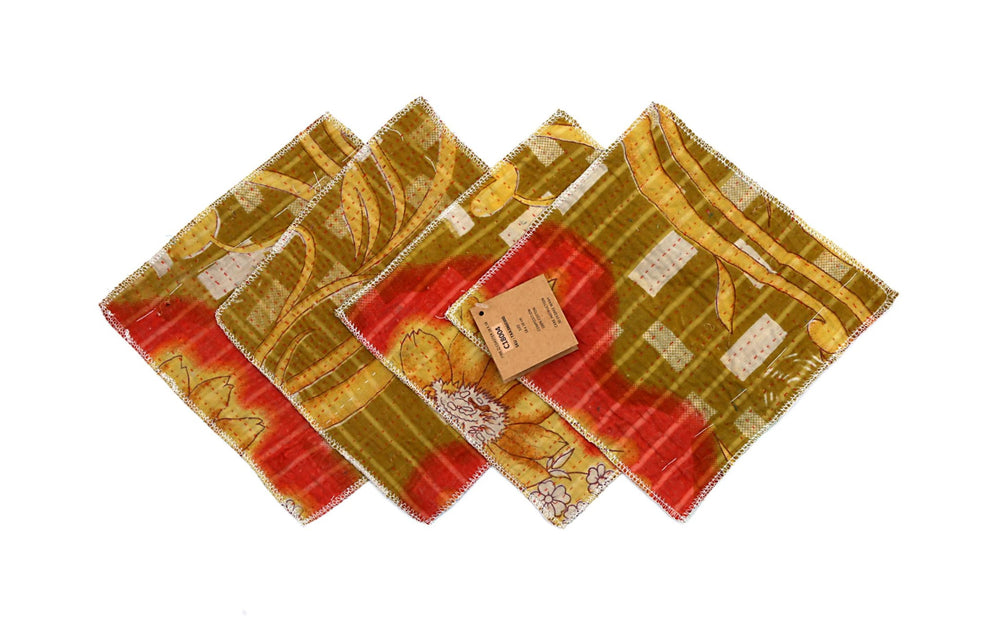 Set mit 4 Untersetzern (18 x 18 cm) in Grün, Gelb und Rot mit dekorativem Blumenmotiv und leicht geprägten, gesteppten Rändern.