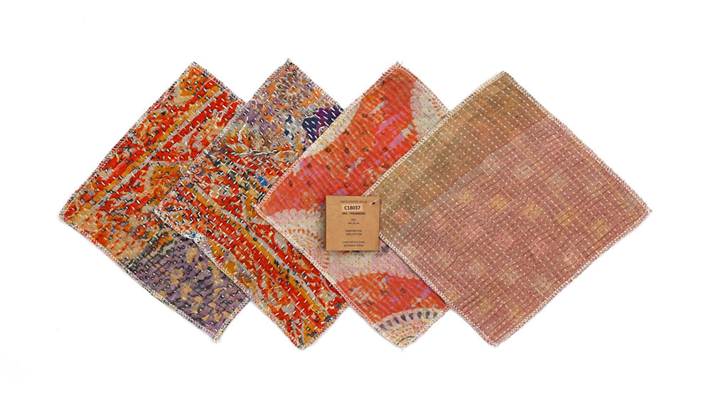 Set mit 4 Untersetzern (18 x 18 cm) im Patchwork-Muster mit roten, orangen, violetten und beigen Farben und sichtbaren Stickereirändern.
