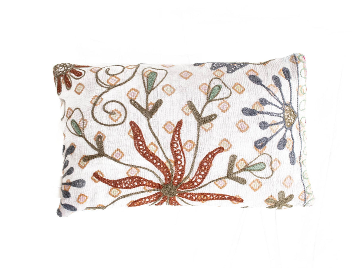 Weißer Suzani-Kissenbezug 30x50 cm mit farbenfroher orientalischer Stickerei: gewundene Blüten in Terrakotta, Dunkelblau und Staubgrün, Boho-Vintage-Stil.
