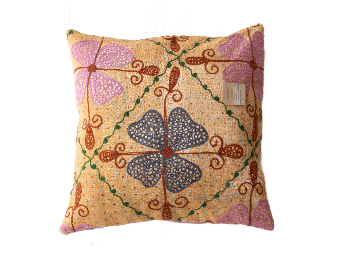 Einzigartiger Suzani-Kissenbezug 50x50 cm aus sandfarbenem Stoff mit farbenfrohem Vintage-Boho-Ethno-Muster aus lila Herzen, grünen Ranken und braunen Schlingen.
