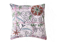 Einzigartiger Suzani-Kissenbezug 50x50 mit weißem Grund und farbenfrohen, gestickten Blumen sowie grünen Blättern und schwarzen Schlingenornamenten im Boho-Vintage-Stil.