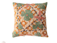 Suzani Kissenbezug im Boho-Vintage-Stil mit orangefarbenem Grundton und weißen floralen Ornamenten sowie großen grünen Blättern mit rosa Punkten und dunkelblauen Ranken.